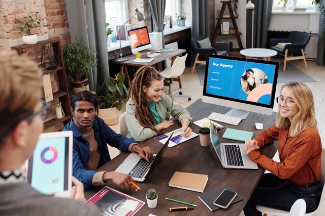Team of diverse colleagues collaborating on project in modern office with digital devices and charts. Branding agency reviews in England: the evidence pack to request